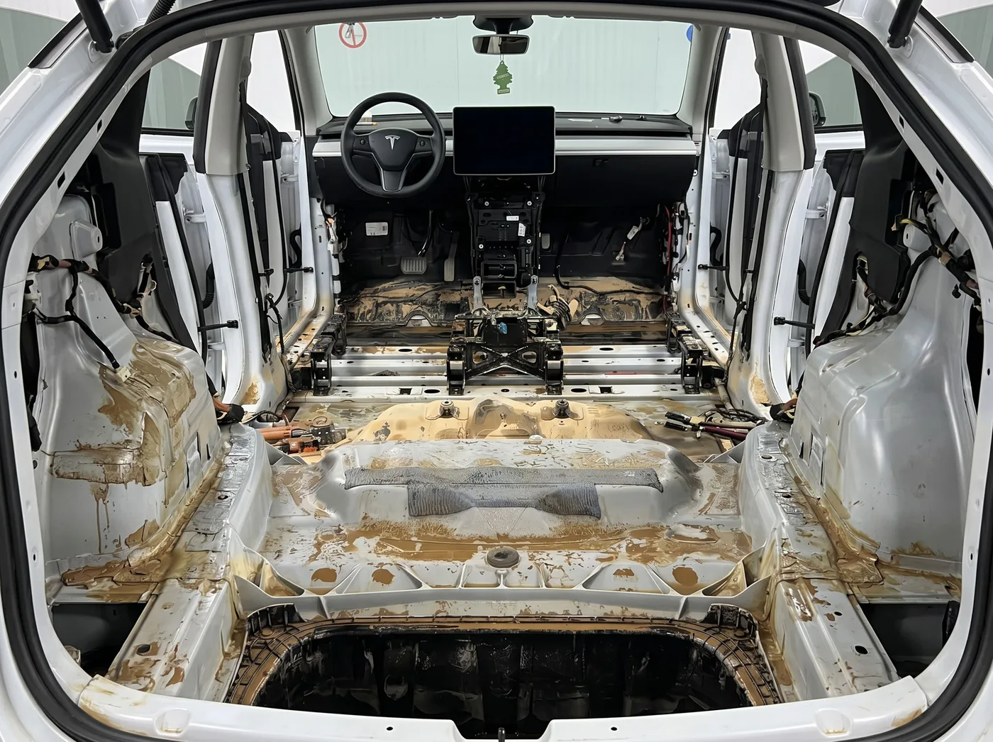 泡水 Tesla 拆除座椅、地毯與內裝後，車室底板佈滿泥沙